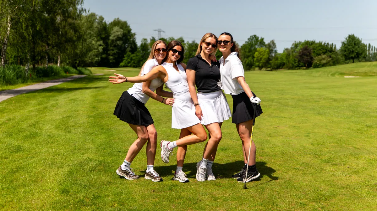 Vier deelneemsters in een uitbundige pose op de fairway
